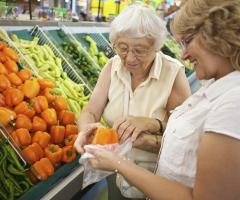 Volunteer helping elderly women with her fruit and veg shopping