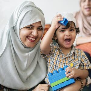 Muslim mum playing with her child