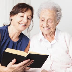 Volunteer reading to elderly woman