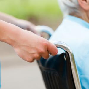 Community worker pushing a client in a wheelchair