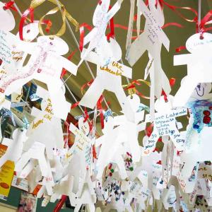 Dozens of paper cut out people with messages written on them
